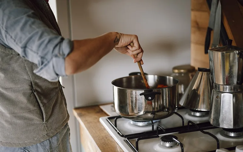 Olla en la estufa y cafetera sobre la cubierta